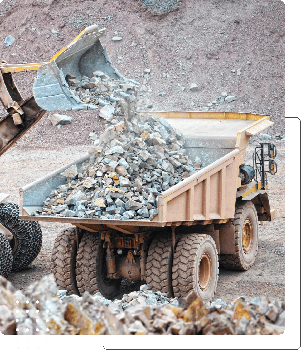 Loader dumping rocks into a large truck.